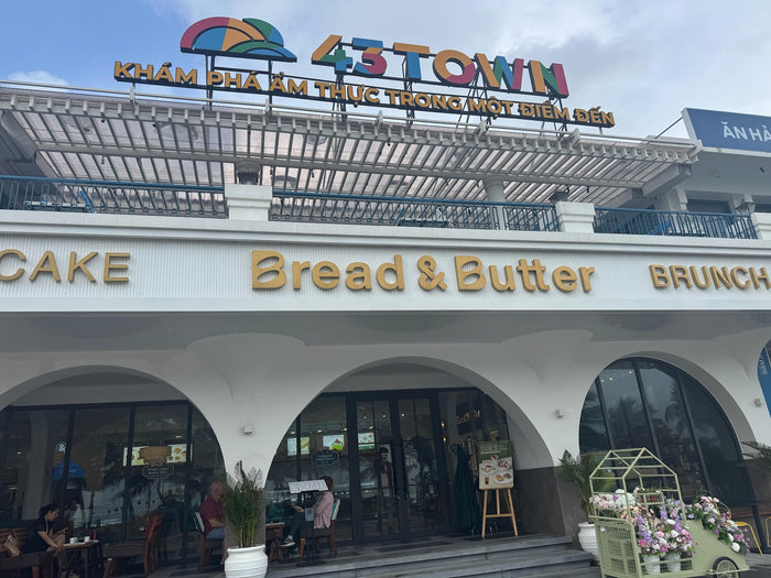 Exterior of Bread & Butter in Da Nang, Vietnam — photographed by Mike & Stacy Abroad for Da Nang, Vietnam. A bright beachfront café with arched entrances, ocean-facing seating, and a welcoming pastry and brunch atmosphere.